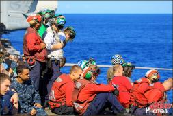 Flight deck crew take a moment to sit down and enjoy the Air Power Demonstration Airshow onboard the USS Abraham Lincoln. - Photo by Britt Dietz Flight deck crew take a moment to sit down and enjoy the Air Power Demonstration Airshow onboard the USS Abraham Lincoln. - Photo by Britt Dietz